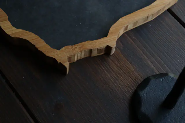 Close-up of a Borderframe’s laser-cut bamboo edge on a dark wooden table