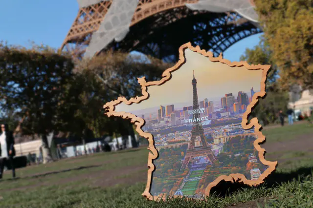 France Borderframe with a photo of Paris, leaning on the lawn below the Eiffel Tower