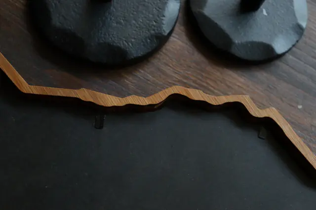 A Borderframe’s outline against dark wood and black card