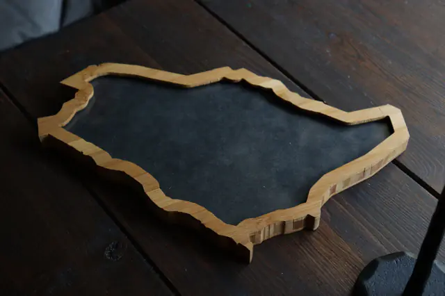 An empty Saudi Arabia Borderframe on a dark wooden table